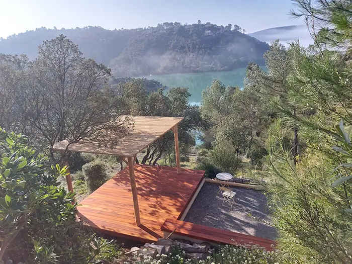 Terrasse en bois installée sur un terrain en pente avec pergola